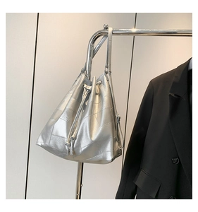Detail of silver metallic bucket bag with geometric stitching and drawstring closure