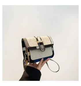 Close-up of woven straw handbag featuring vintage plaid strap and golden metal clasp