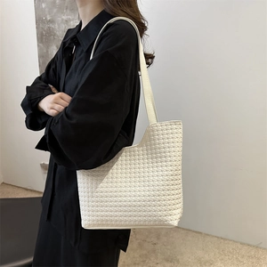 Minimalist white woven tote bag shown on model with chic woven texture and large capacity