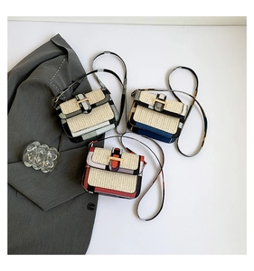 Flat lay of woven crossbody bags with gold H-buckle and contrast faux leather detail
