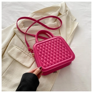Detailed texture of hot pink quilted rhombic pattern leather bag with golden hardware