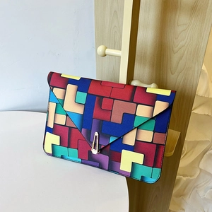 Colorful geometric mosaic envelope clutch bag with stylish metal buckle on shelf
