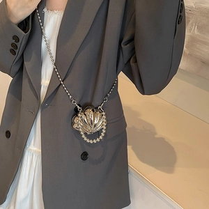 Chic silver shell-shaped mini crossbody bag with metallic ridges and bead chain