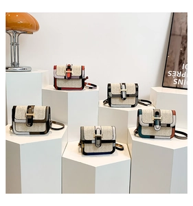 Detailed view of woven straw crossbody bags with colorful leather trim and gold H-buckle