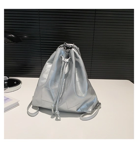 Detail of silver quilted bucket bag featuring metallic texture and drawstring closure