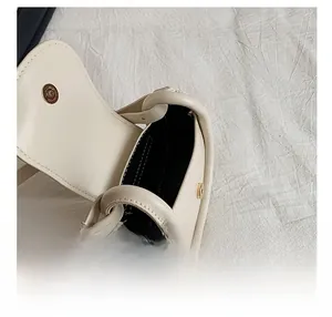 Detail view of the cream leather mini bag interior with magnetic clasp and black lining