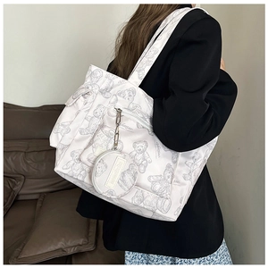 Detail of white tote bag featuring gray bear prints and a detachable round coin purse