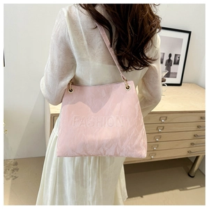 Detail of light pink tote bag with FASHION embossed logo and gold metal rings