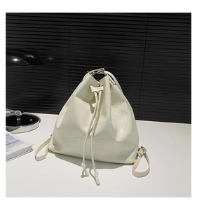 Detail of off-white leather bucket bag with patchwork design and drawstring closure
