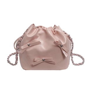 Sac seau rose en cuir verni avec bandoulière en chaîne argentée et nœuds élégants
