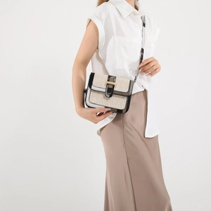 Chic woven patchwork crossbody bag with gold lock and checkered strap worn by model
