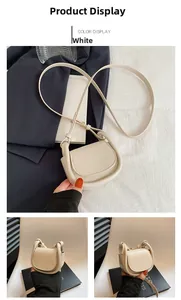 Detail of white mini saddle bag showing pebble grain faux leather and magnetic flap