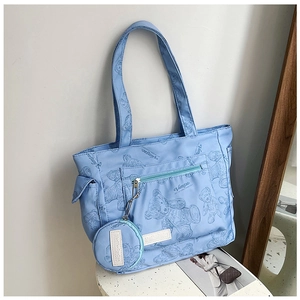 Detail of light blue teddy bear print tote bag featuring a matching round coin purse