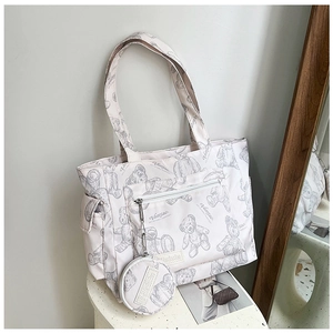 Detailed view of beige tote bag with bear print, side pocket and small round coin purse