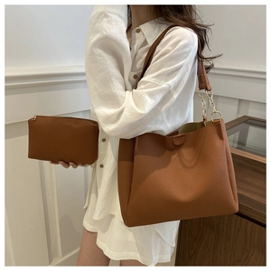 Dettaglio della borsa tote marrone in pelle martellata con pochette e catena dorata