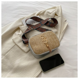 Detail of straw crossbody bag with silver PU patchwork and retro patterned wide strap
