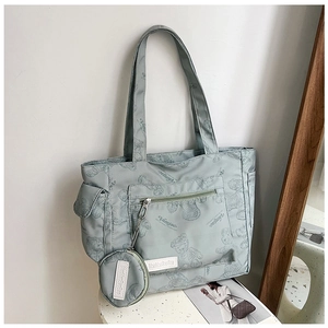Detail of light blue tote bag with teddy bear prints and matching small round pouch