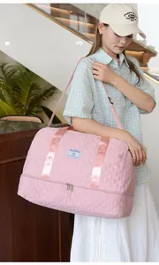 Detailed view of pink quilted travel bag showing independent shoe compartment and texture