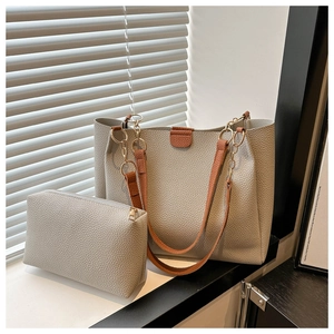 Dettaglio set borse tote grigie con texture litchi, catena dorata e manici marroni