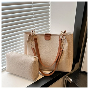 Dettaglio del set borsa tote due pezzi in pelle martellata con catena dorata chic