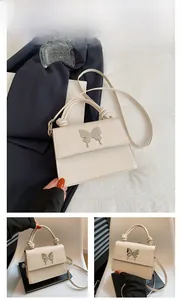 Détail du sac à bandoulière blanc avec papillon argenté et poignée au design noué