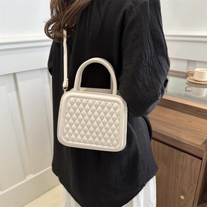 Elegant cream white quilted crossbody bag with a curved top handle and diamond stitching