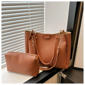 Set borsa tote in pelle martellata caramello con catena e pochette coordinata su davanzale