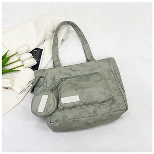Detail of green tote bag with bear print featuring front zipper pocket and round pouch