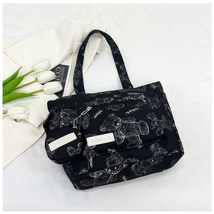 Macro shot of black tote bag featuring white bear prints and mini round coin purse