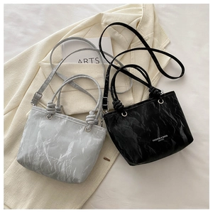 Gros plan de sacs en cuir plissé gris pierre et noir avec détails de nœuds
