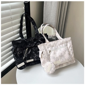Detail of printed large tote bags in black and cream featuring cute bear motifs