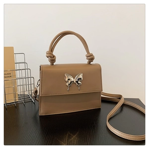 Détail du sac à main carré en cuir PU kaki avec boucle papillon argentée et poignée nouée