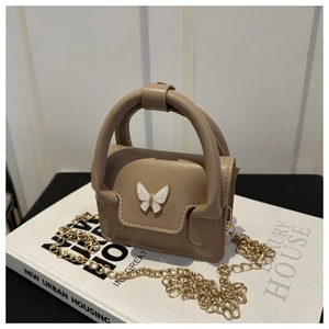 Detailed close-up of khaki mini bag featuring white butterfly metal buckle and chain strap