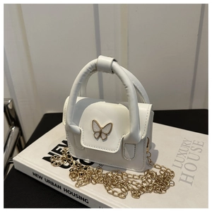Macro shot of white PU leather handbag with gold butterfly buckle and chain strap
