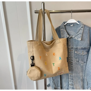 Détail du sac cabas en toile avec broderie colorée et un mini porte-monnaie amovible