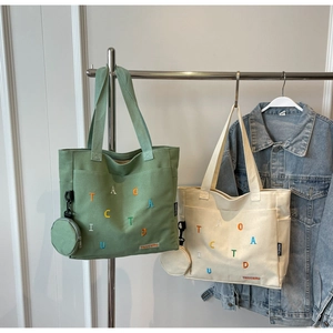 Détail du sac fourre-tout en toile brodée avec une petite pochette ronde assortie