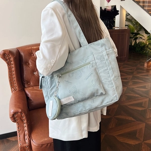 Light blue tote bag with bear pattern and coin pouch shown on model in retro room