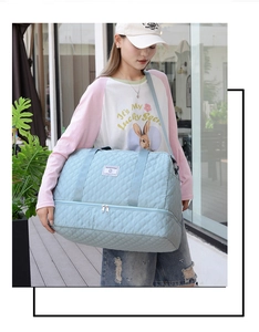 Detail of light blue quilted travel bag with double-layer design for dry and wet separation