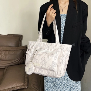 Large beige tote bag with bear sketch print and matching coin purse on shoulder