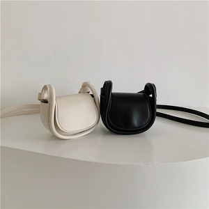 Minimalist mini round flap crossbody bags in white and black semi-matte synthetic leather