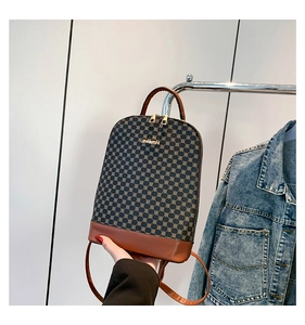 Detail of vintage patterned backpack with JINGPIN metal logo and gold dual zippers
