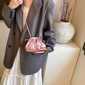 Metallic pink ruched mini crossbody cloud bag worn by model with elegant style