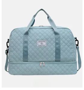 Detail of blue quilted gym bag showing large capacity and bottom shoe compartment
