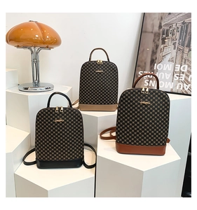 Detailed view of three checkered mini backpacks in black, khaki and brown on display