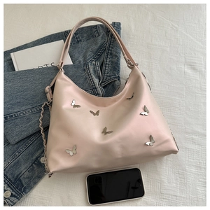 Detail of light pink crescent bag featuring silver metallic butterfly embellishments