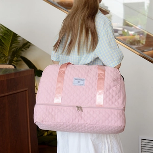 Pink quilted travel bag with large capacity, shoe compartment and adjustable shoulder strap