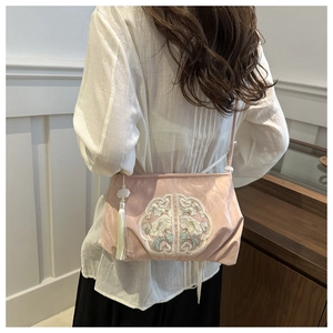 Detailed embroidery with floral patterns and silk tassel on pink crossbody bag