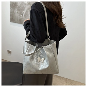 Sac fourre-tout argenté pailleté avec boucle papillon en métal en décor de vie