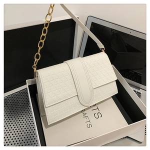 Détail du sac bandoulière blanc texturé avec chaîne dorée et sangle en cuir