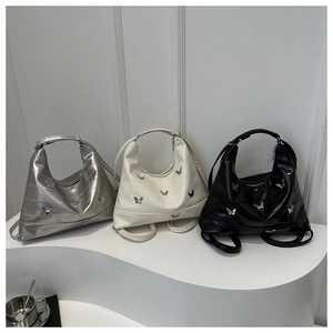 Detail view showing three colors of chic hobo bags with metallic butterfly accents
